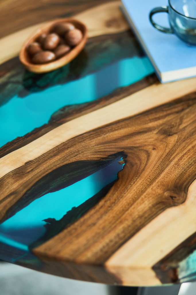 Close up of epoxy wooden coffee table with glass , nuts and book